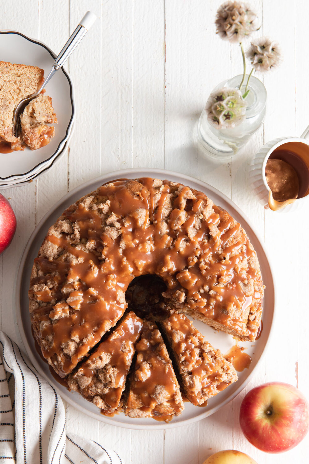An overhead photo of a apple coffee cake with a crumb topping and caramel sauce.
