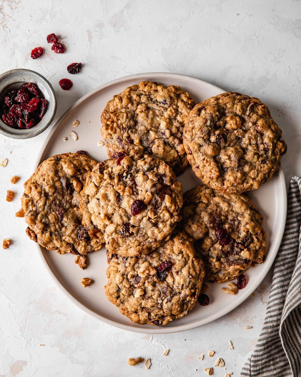 A plate of giant oatmeal cookies with dried cranberries and chocolate chips.