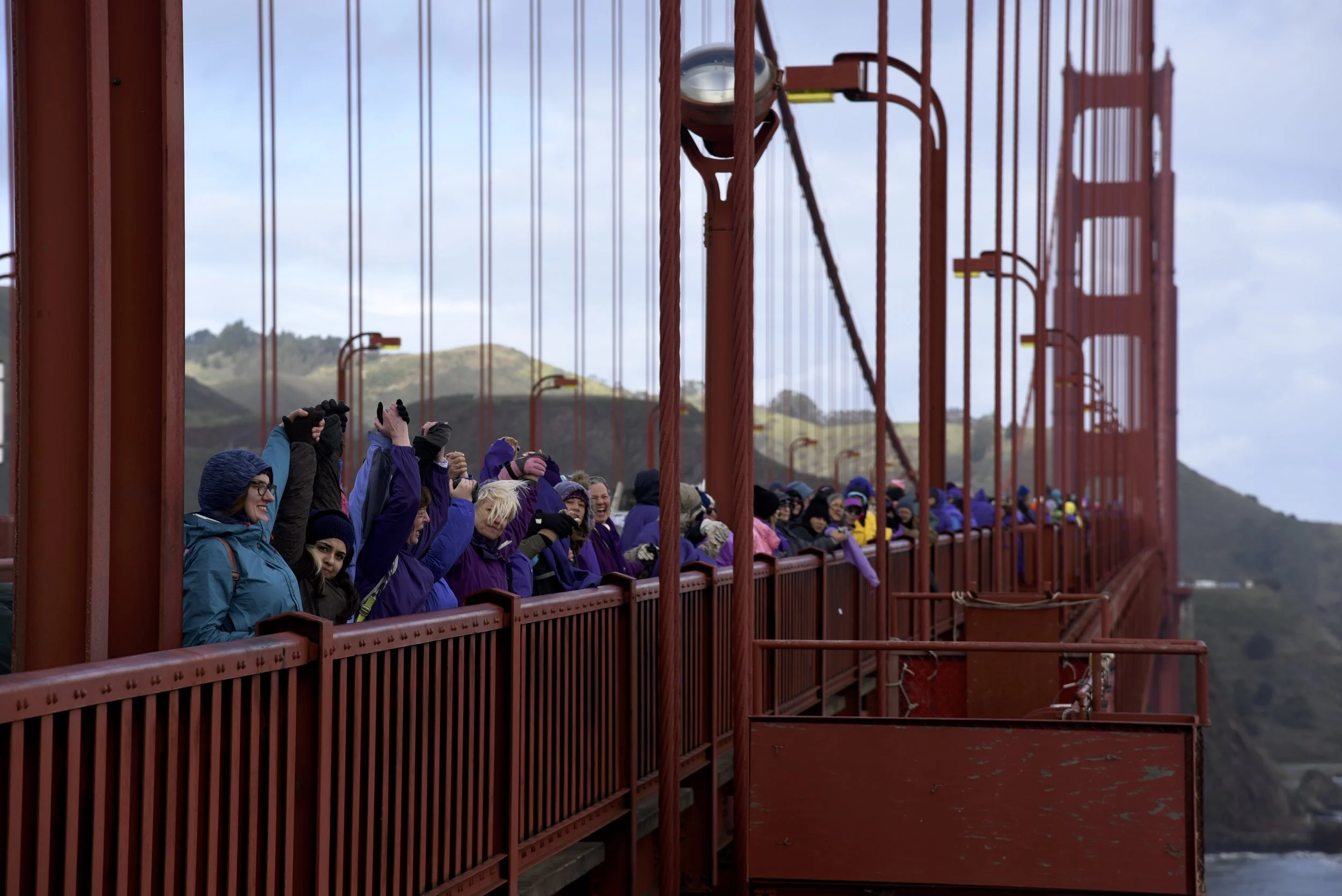 Thousands of protesters hold hands and wear purple to show solidarity and unity during Donald Trump's presidency, according to Bridge Together Golden Gate volunteers, at the Golden Gate Bridge in San Francisco, Calif., on Friday, January 20, 2017.