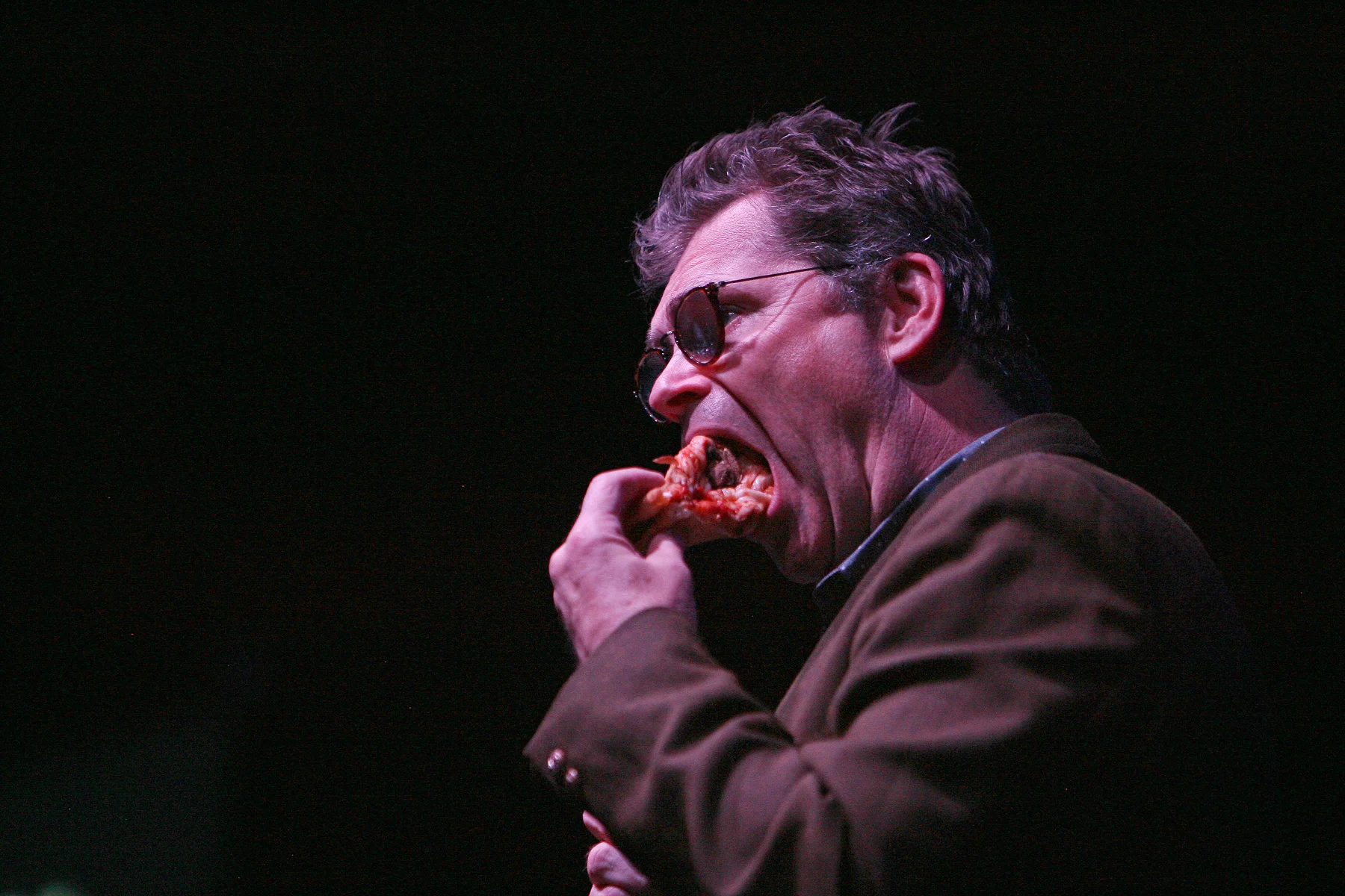 Dana Gould enjoying some pizza onstage LOCATION: Press Room PHOTO CREDIT: Matt Santos