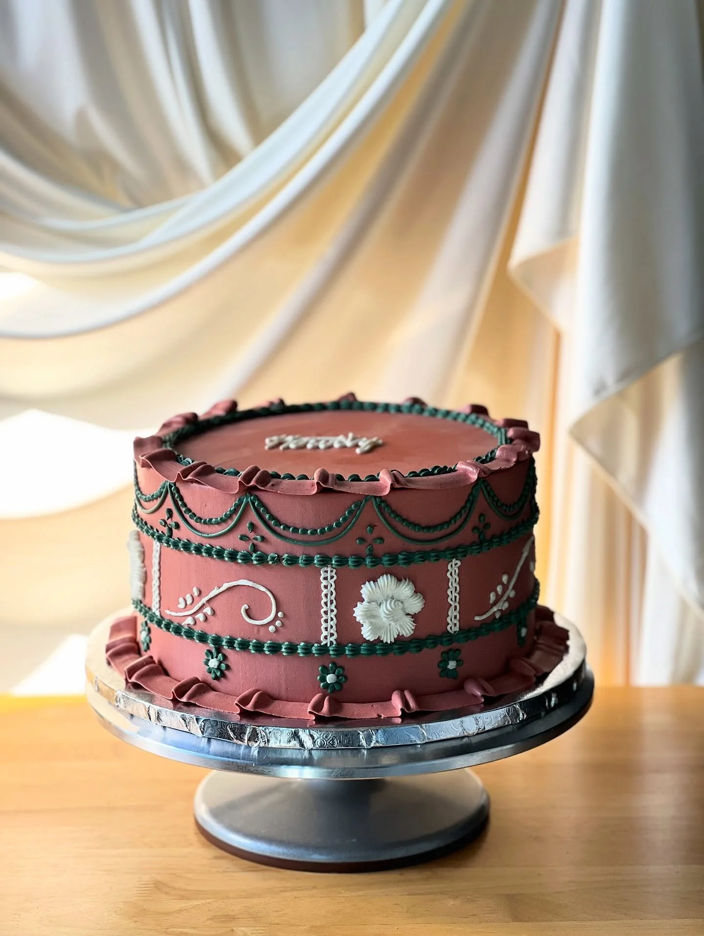 __
✨ A little slice of vintage charm ✨
This handcrafted beauty combines a soft terracotta base with delicate piping in deep green and ivory &mdash; every swirl and ruffle made with love. The floral accents and retro-inspired details make it not just 