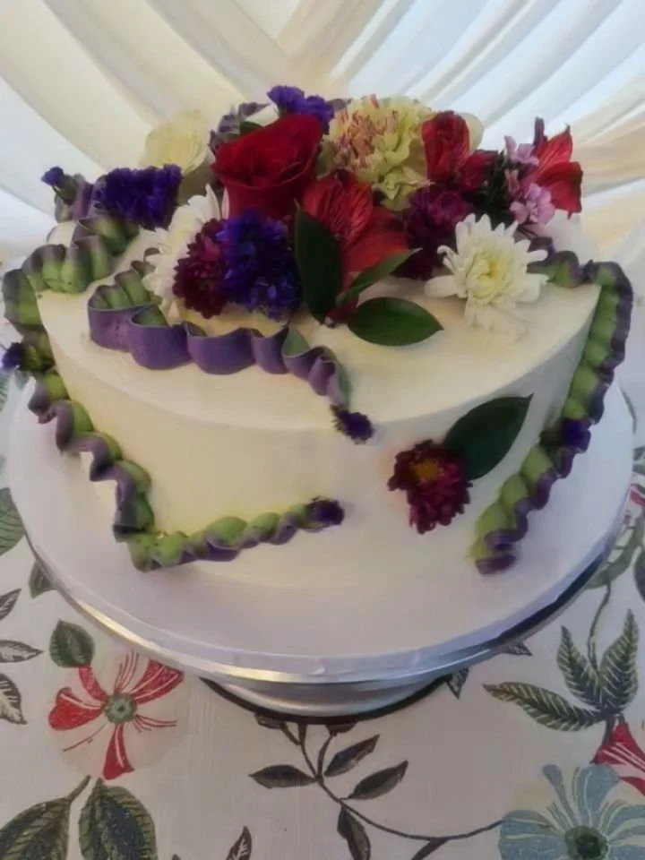 Fresh florals and buttercream elegance 🌸
This gluten free beauty is topped with a vibrant arrangement of blooms and finished with soft, handcrafted details&mdash;timeless, bold, and completely celiac-safe. Every element is made with care so you can 