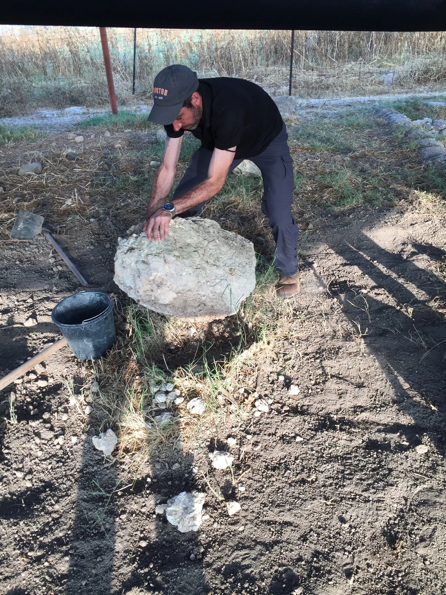 Co-Director Dr. Mario Martin moves large stones out of an excavation area