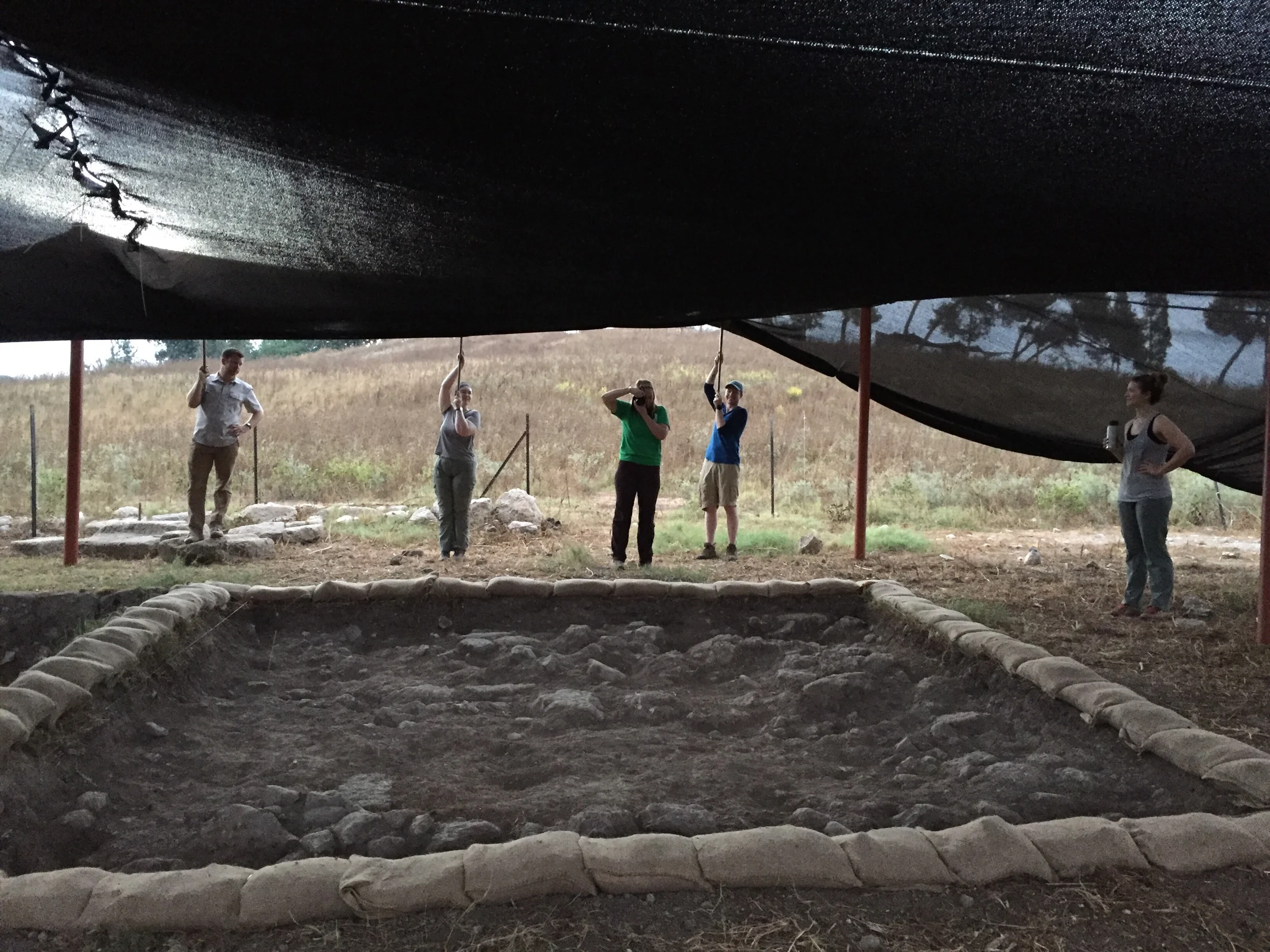 Holding up the shade cloth for a photograph