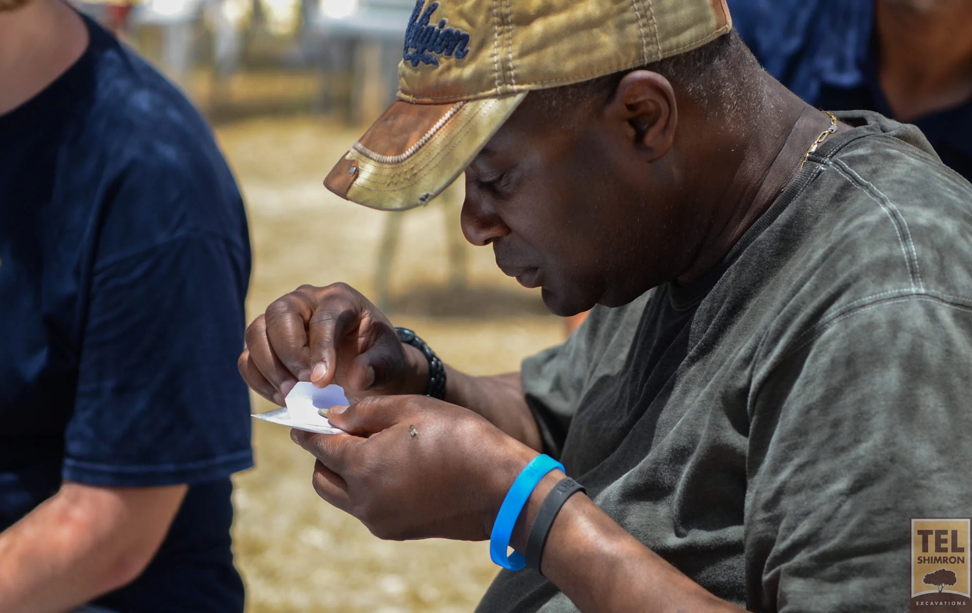 Examining a coin found during excavation