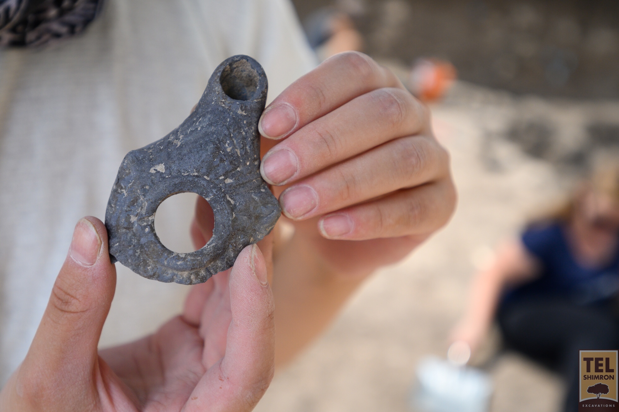 A volunteer in Grid 92 with a Hellenistic period oil lamp