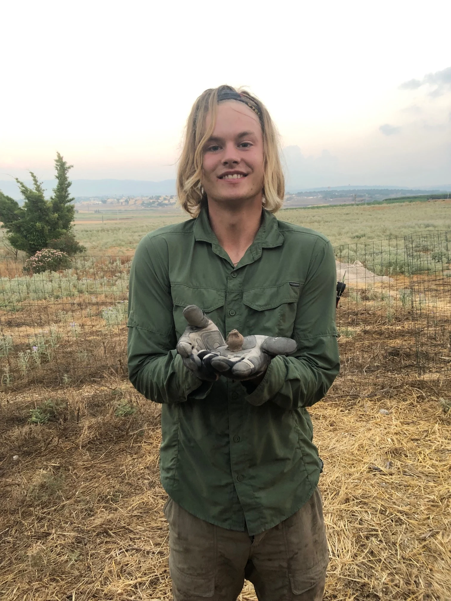 A volunteer in Grid 94 with a little ceramic vessel