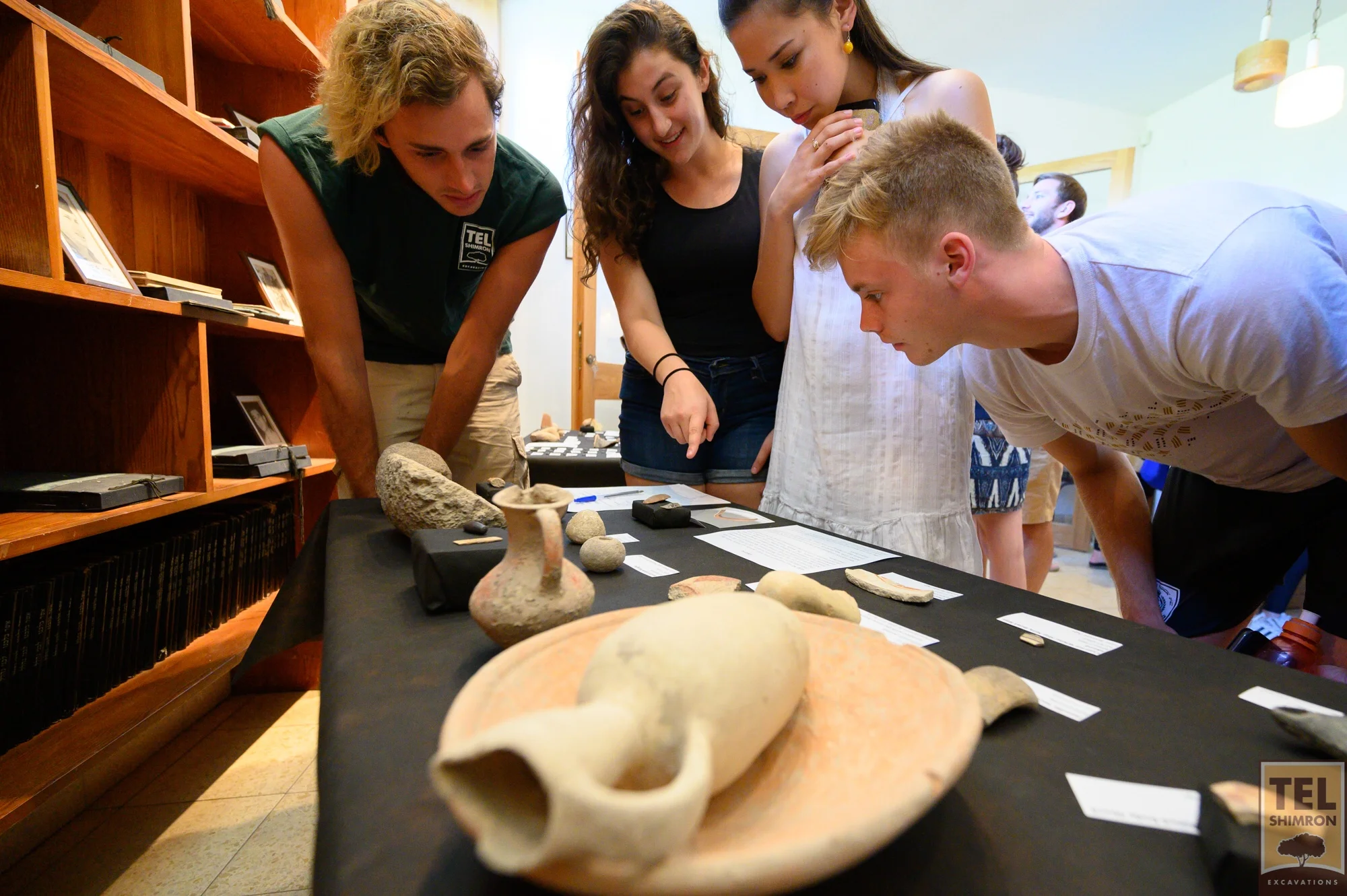 Grid 94 staff and volunteers examining artifacts at the Finds Display