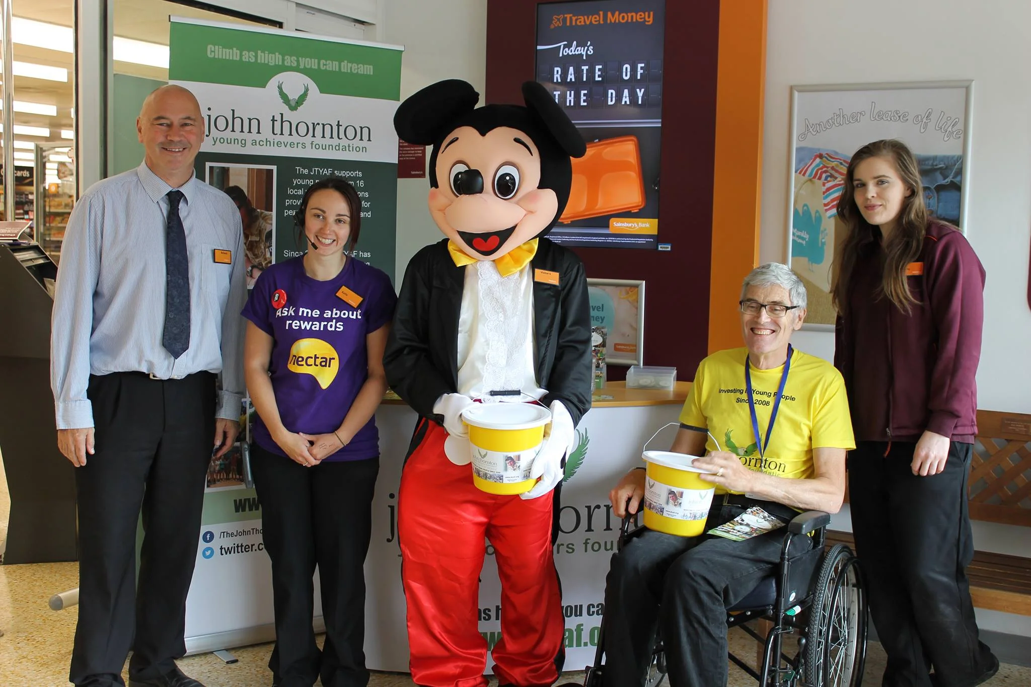 Sainsbury's manager Richard Lockett, a sainsbury's volunteer, mickey mouse, volunteer David Howelett and another sainsbury's volunteer