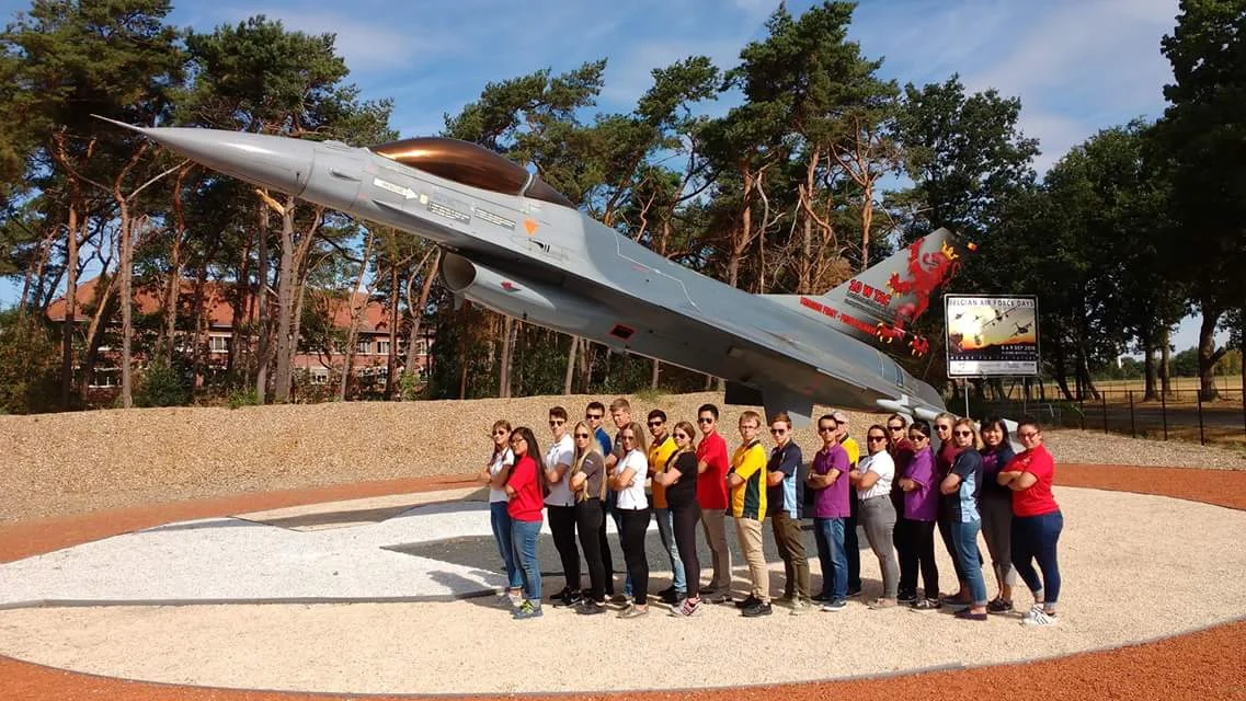 The entire IACE Belgium group posing in front of a F16 at the Air Base of Kleine Brogel