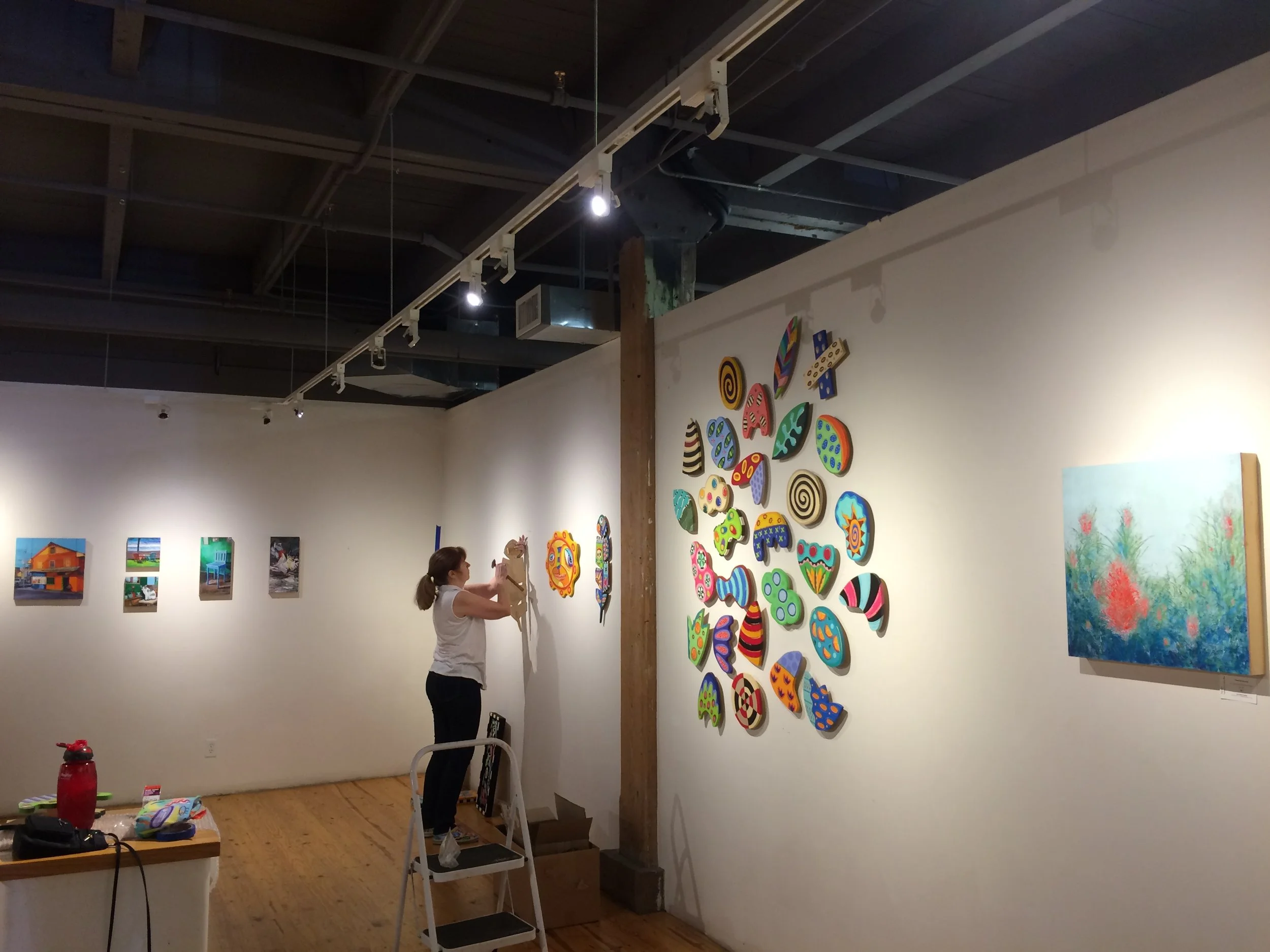 Linda Hatfield hangs her pieces between Katrina's and mine. 