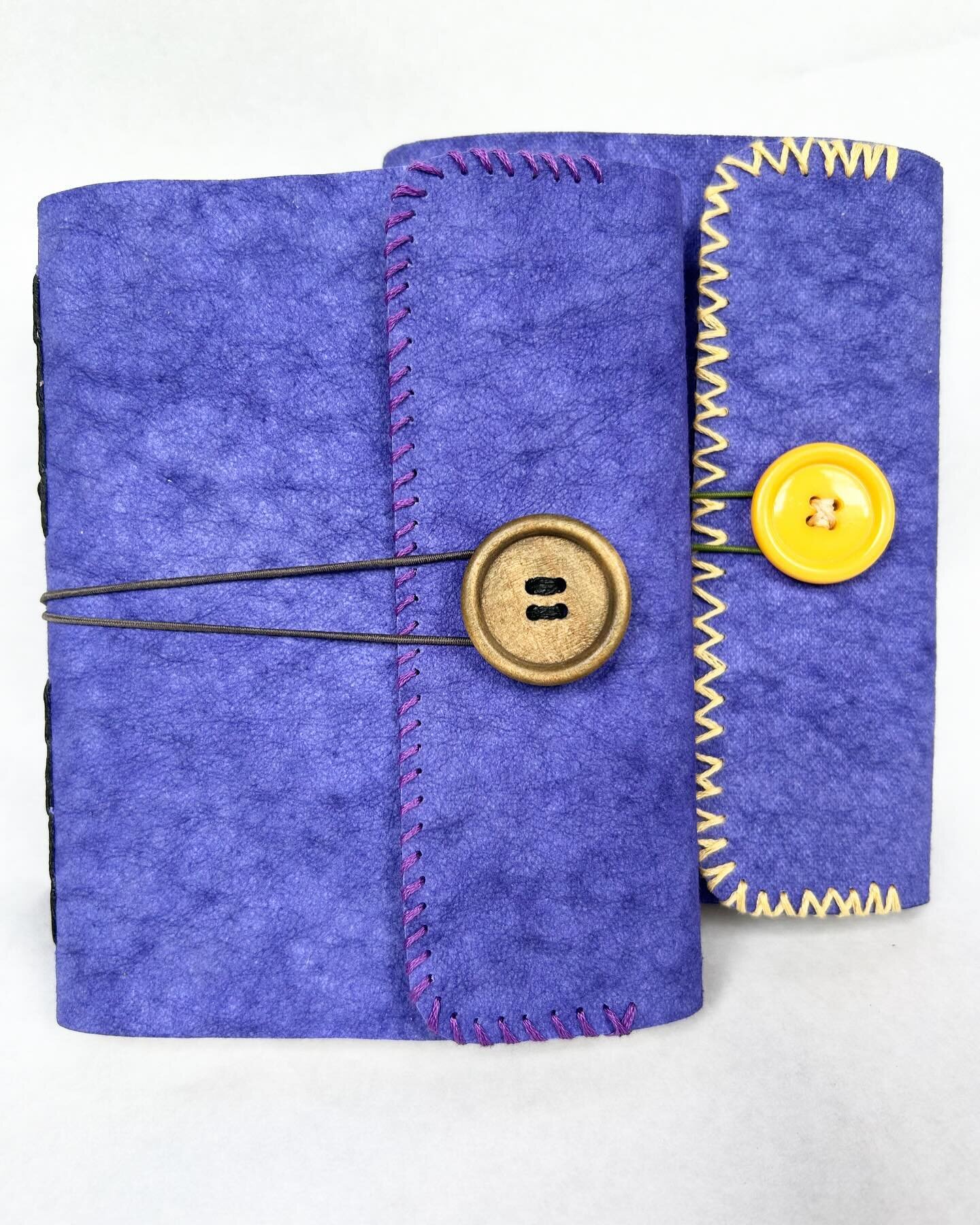 Two more journals. These have Kraft-tex (paper leather) covers, chainlink binding, vintage button closures and some decorative stitching. Each has four signatures (96 pages) of 80-pound sulfite paper wrapped in handmade paper with embedded botanicals