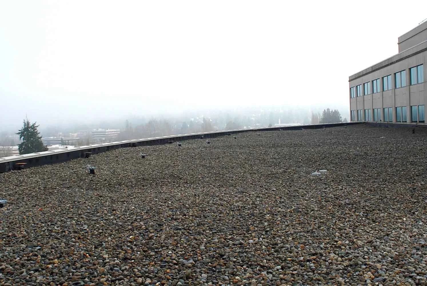 A line cable Fall Protection System on a Ballasted EPDM Single Ply Roofing System