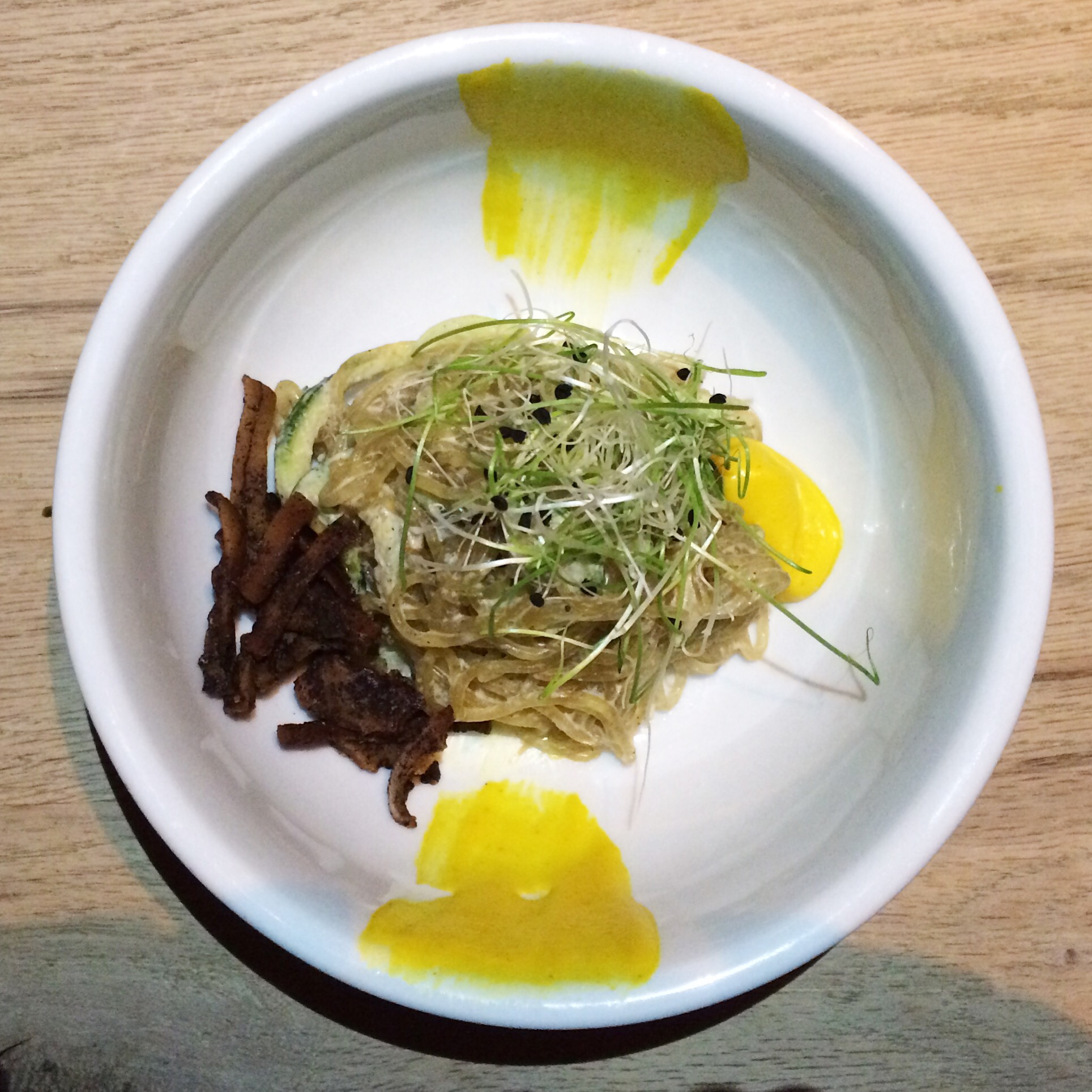 Sixth Course Spaghetti Alla Carbonara kelp and zucchini noodles, black pepper cream, smoked coconut bacon, peas, asparagus, mint, coconut yolk, black olive oil.