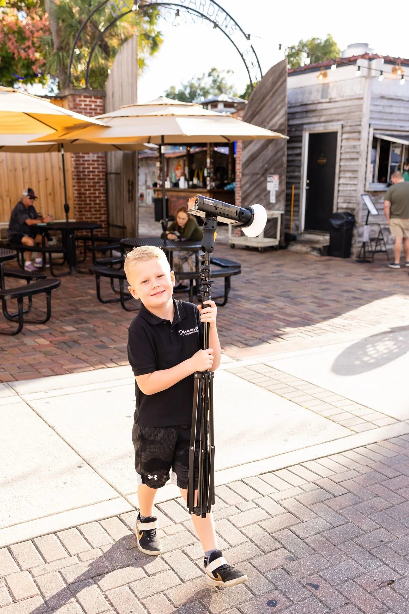 Young family member helping carry photography lighting equipment during a Dreamscape photo session.