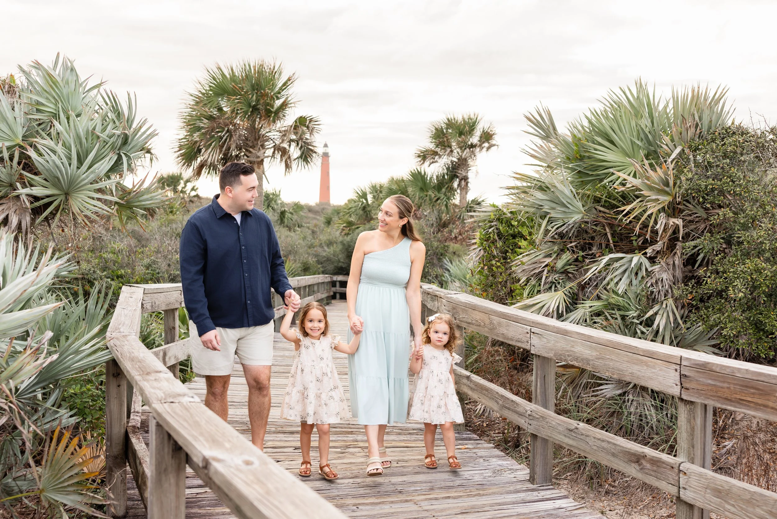 Family portrait session on a beach boardwalk photographed by Dreamscape Photography + Video in Central Florida.