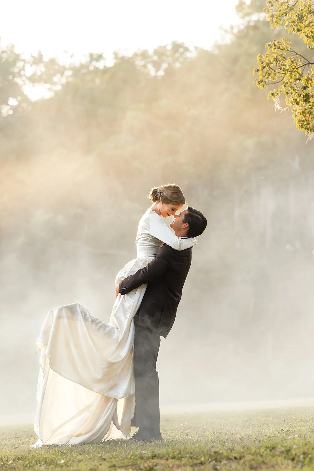 Bride and groom embracing in golden light and mist during a creative Central Florida wedding portrait.