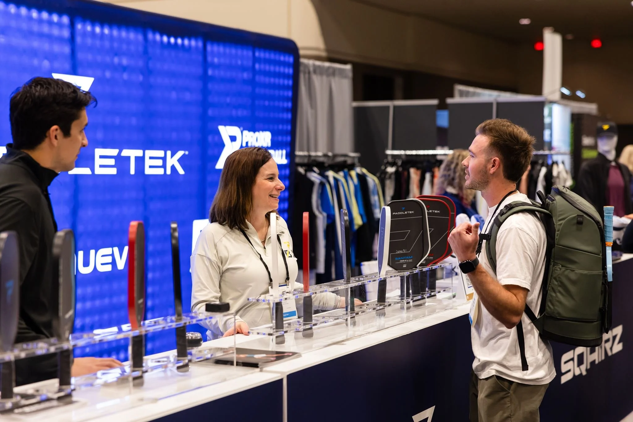 Attendees talking with a vendor at a trade show booth photographed by Dreamscape Photography + Video in Orlando, Florida.