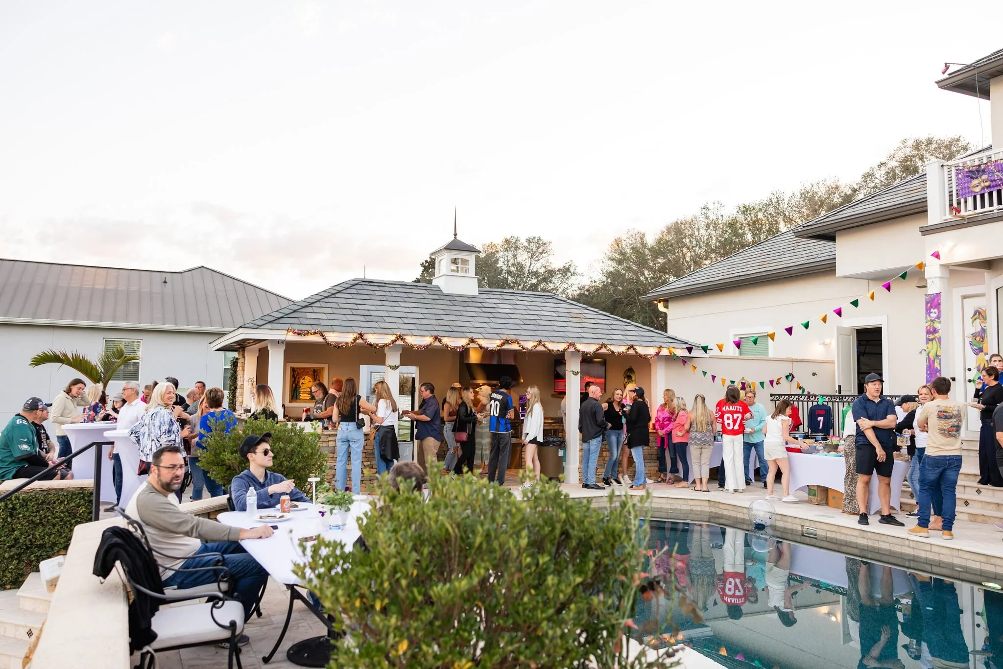 Outdoor private event with guests gathered around a pool photographed by Dreamscape Photography + Video in Central Florida.