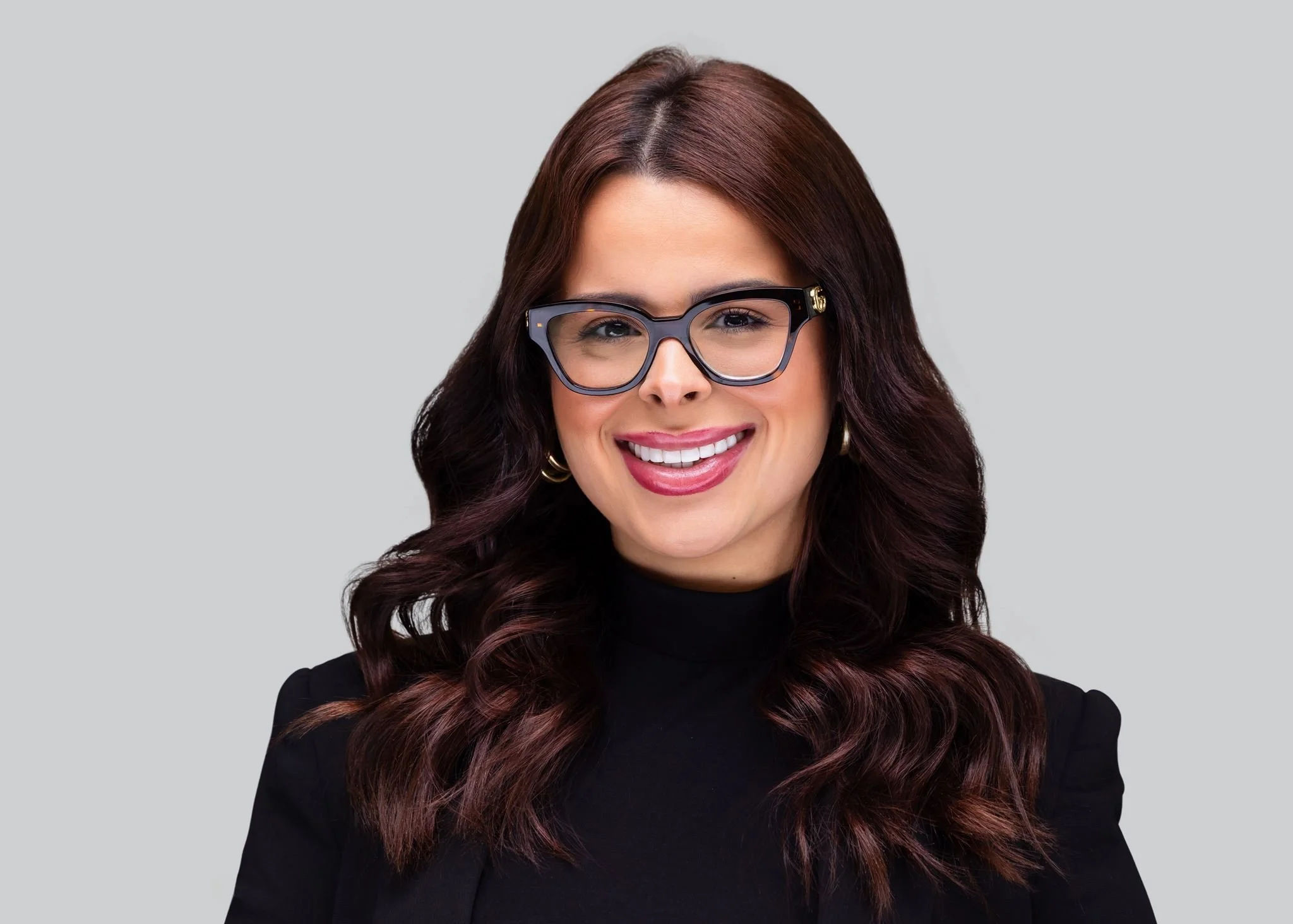 Professional headshot of a woman in black against a light gray background photographed by Dreamscape Photography + Video in Central Florida.