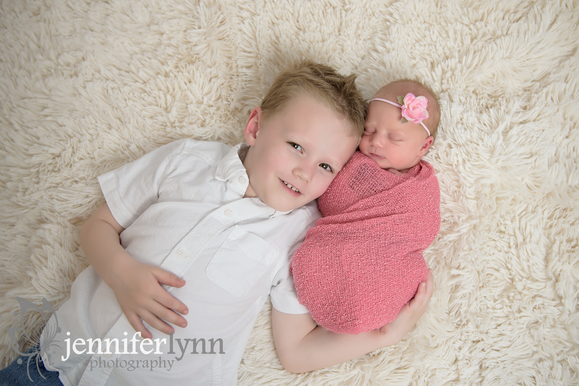 Siblings Laying on Soft Fur Pink Wrap