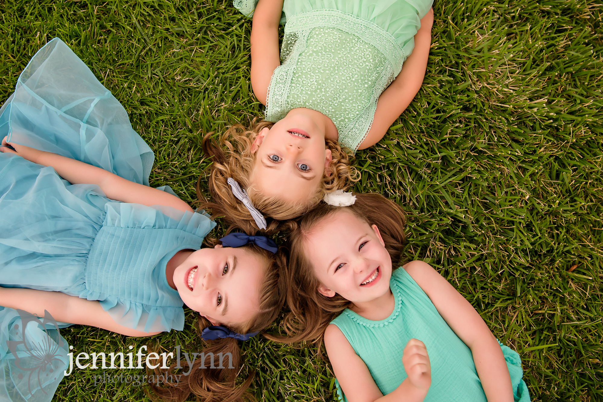 Girl cousins laying on grass looking up