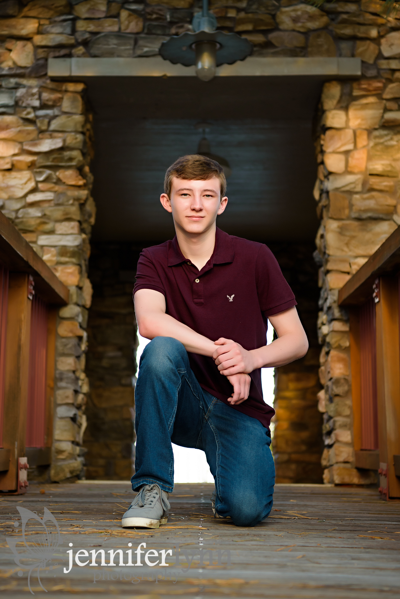 Senior Boy Kneeling on Rustic Bridge