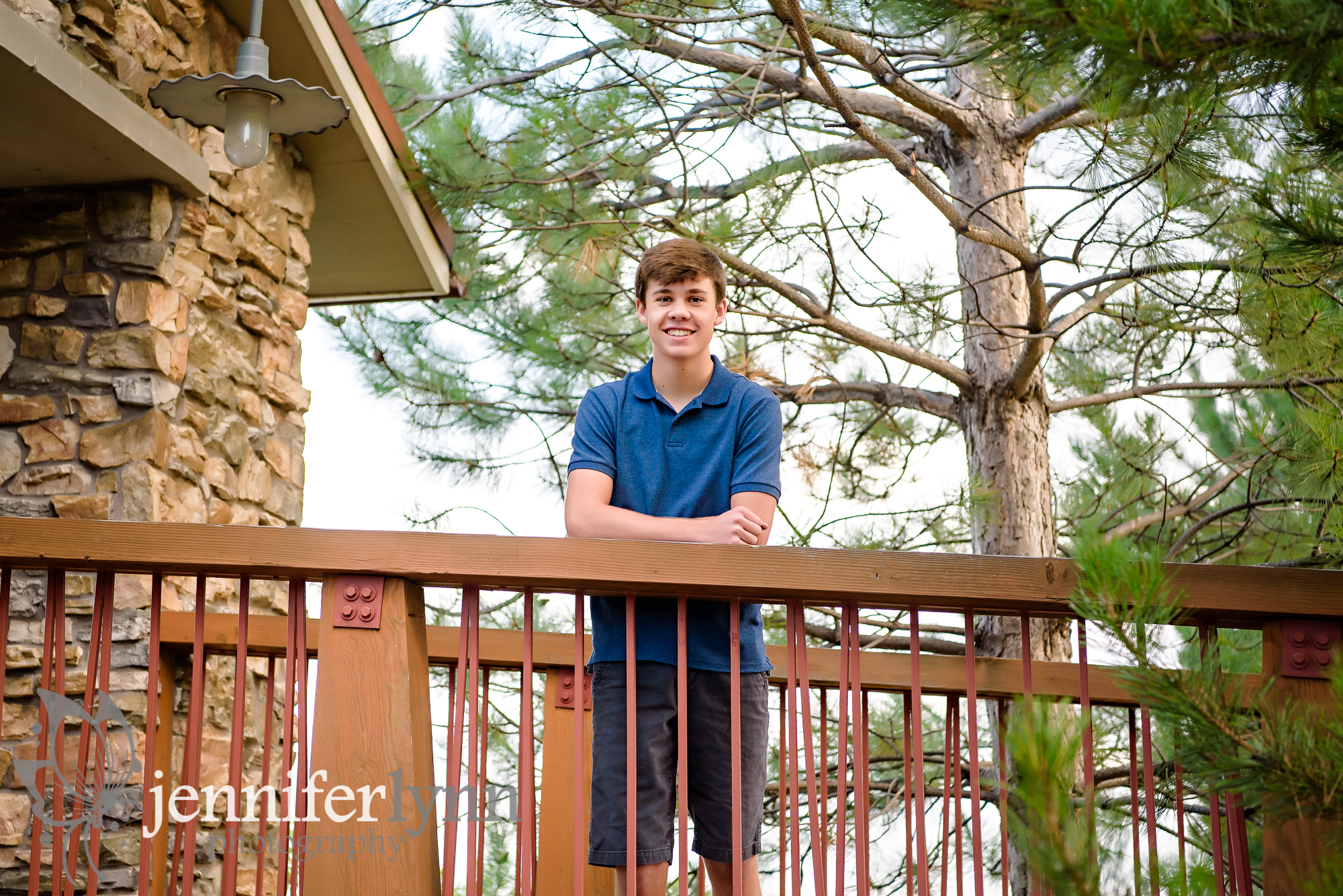 Senior Boy Stands Rustic Bridge