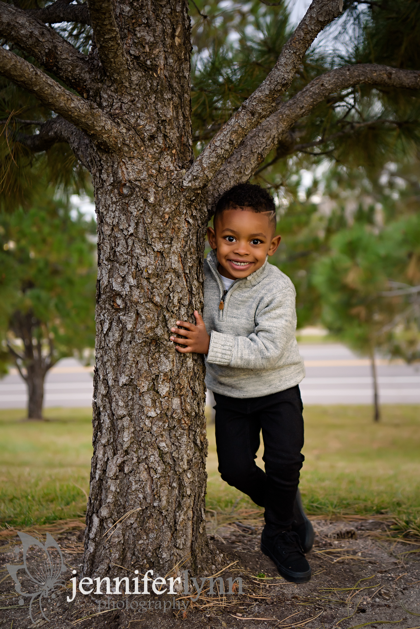 Little Boy Peeking from behind tree