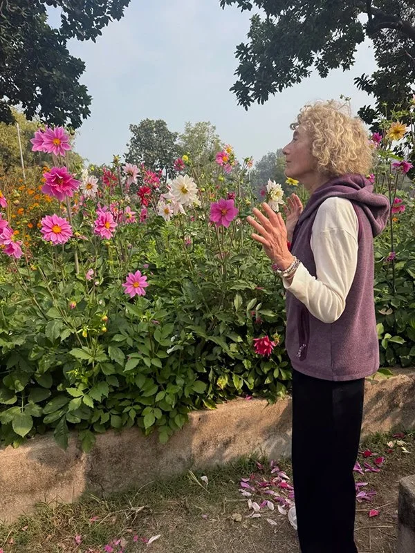 Laura Jane Mellencamp walking mindfully through a garden during her daily meditation practice in India, embodying presence and gratitude.