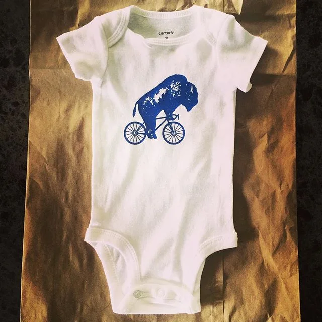 Babies everywhere told us they wanted in on that bike it, Buffalo onesie game. So we said, &quot;Hey baby, here you go!&quot; @bikeitbuffalo #bikeitbuffalo #ridewithoride #baby #onesie #babyfashion #bikes #heybaby