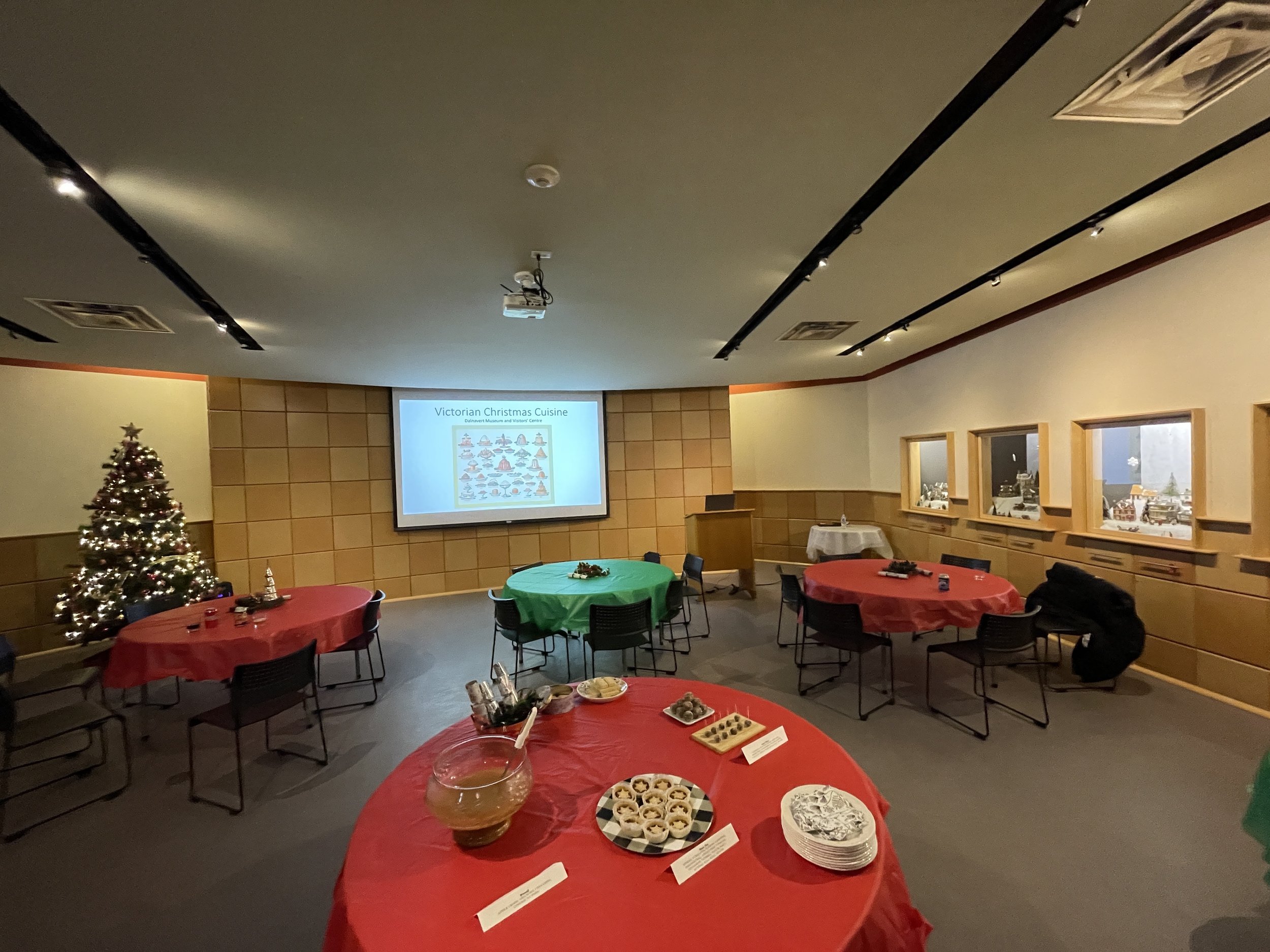  The Visitors’ Centre set for Christmas with round tables with green or red table cloths on them 