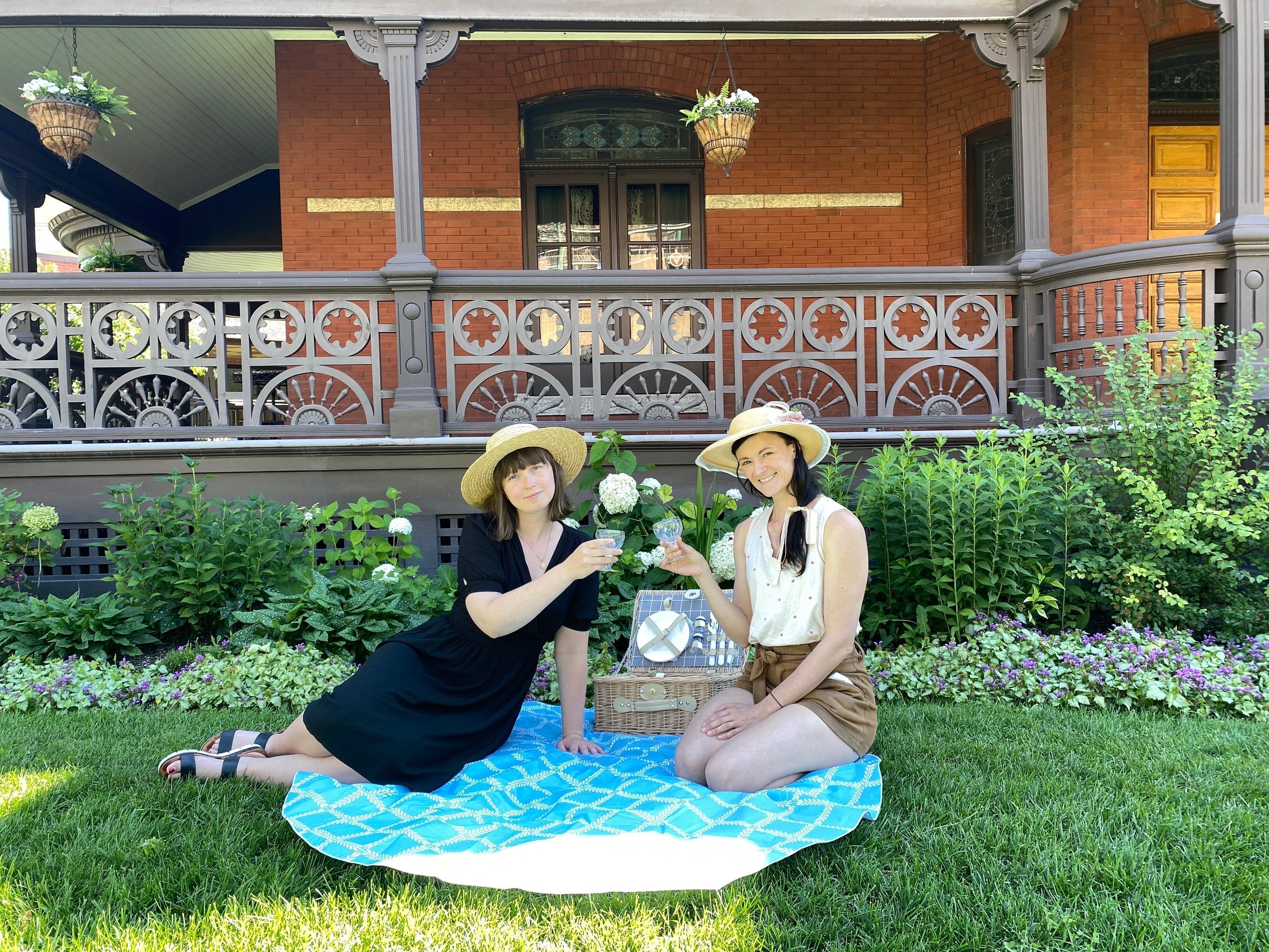  Two people sitting having a picnic on the grounds in front of Dalnavert 