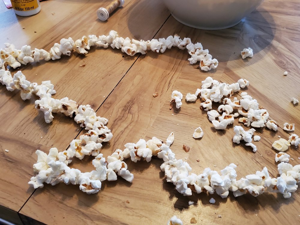  Continue to string popcorns onto the thread, always pushing the needle through the fluffy part of the popcorn 