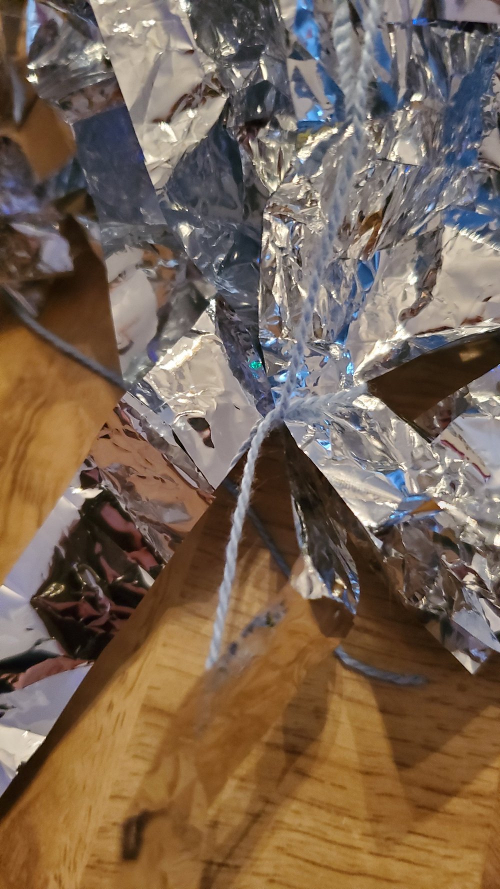  Tie the string to the bottom end of the foil. 