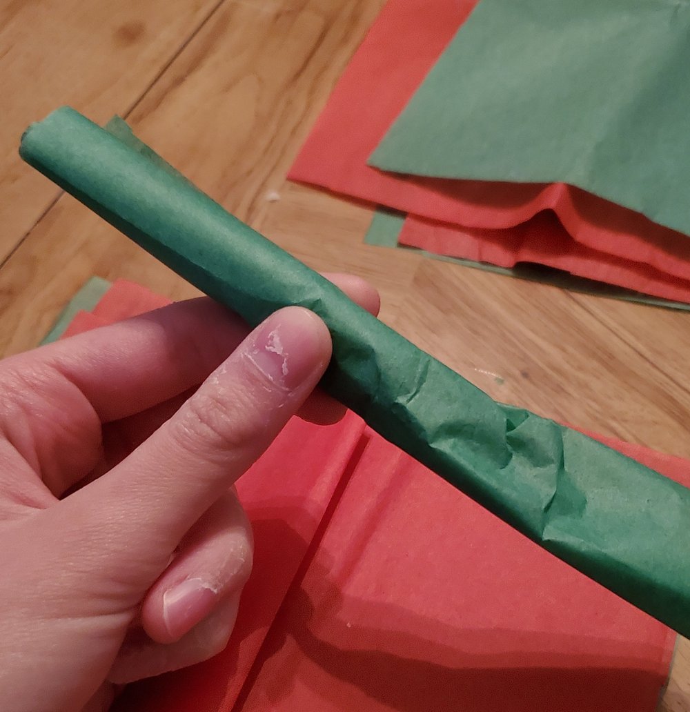  Roll the peanut in the tissue paper, making sure it stays in the middle 