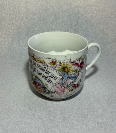 a porcelain mustache cup with handle, and floral decorations in yellow, pink, green, and blue.