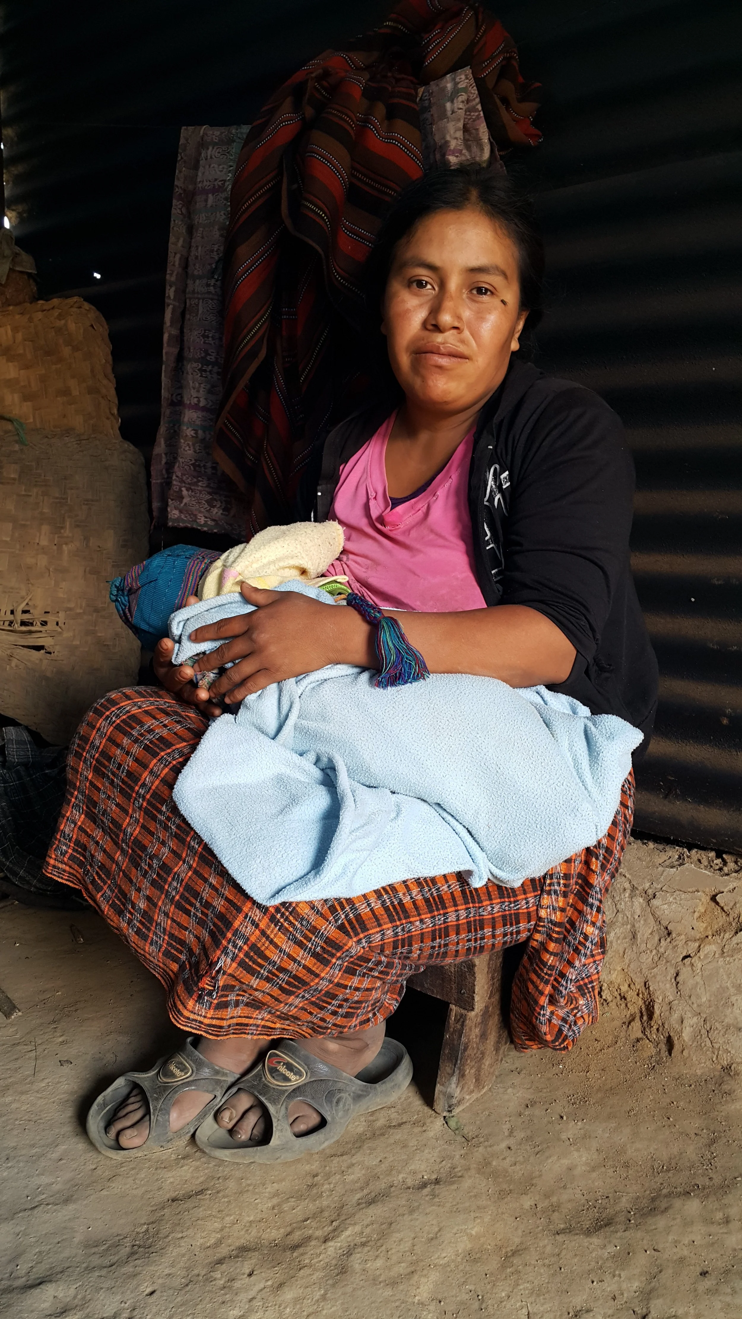 Madelin held by her mother in their former shelter