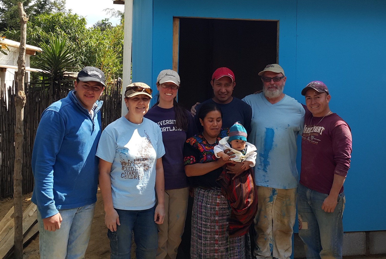  Volunteers and builders with Madelin and her mom outside new home 