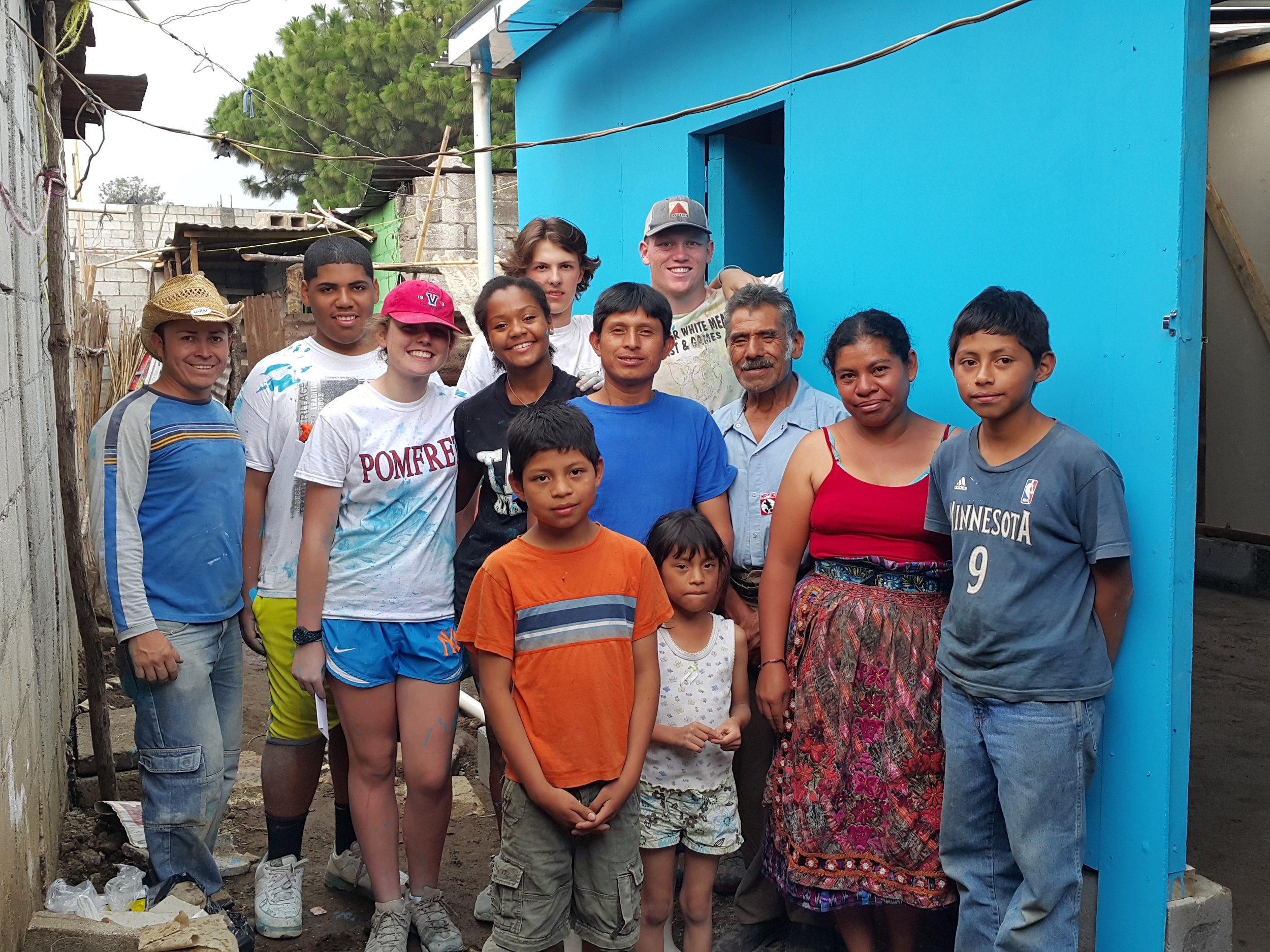 Mynor far right with family members and build volunteers in front of new home
