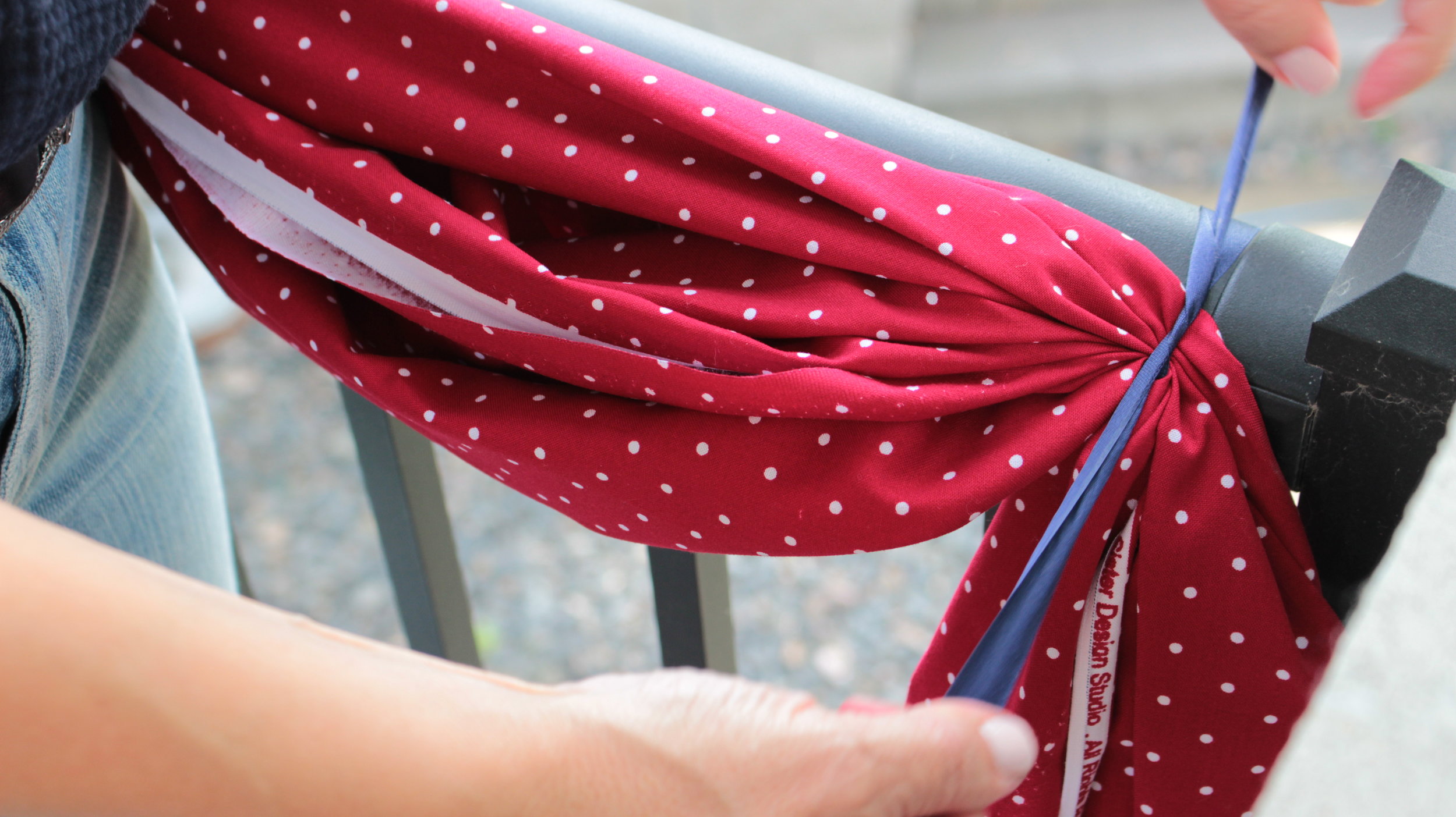 Start with the end of your fabric, and tie onto the railing.