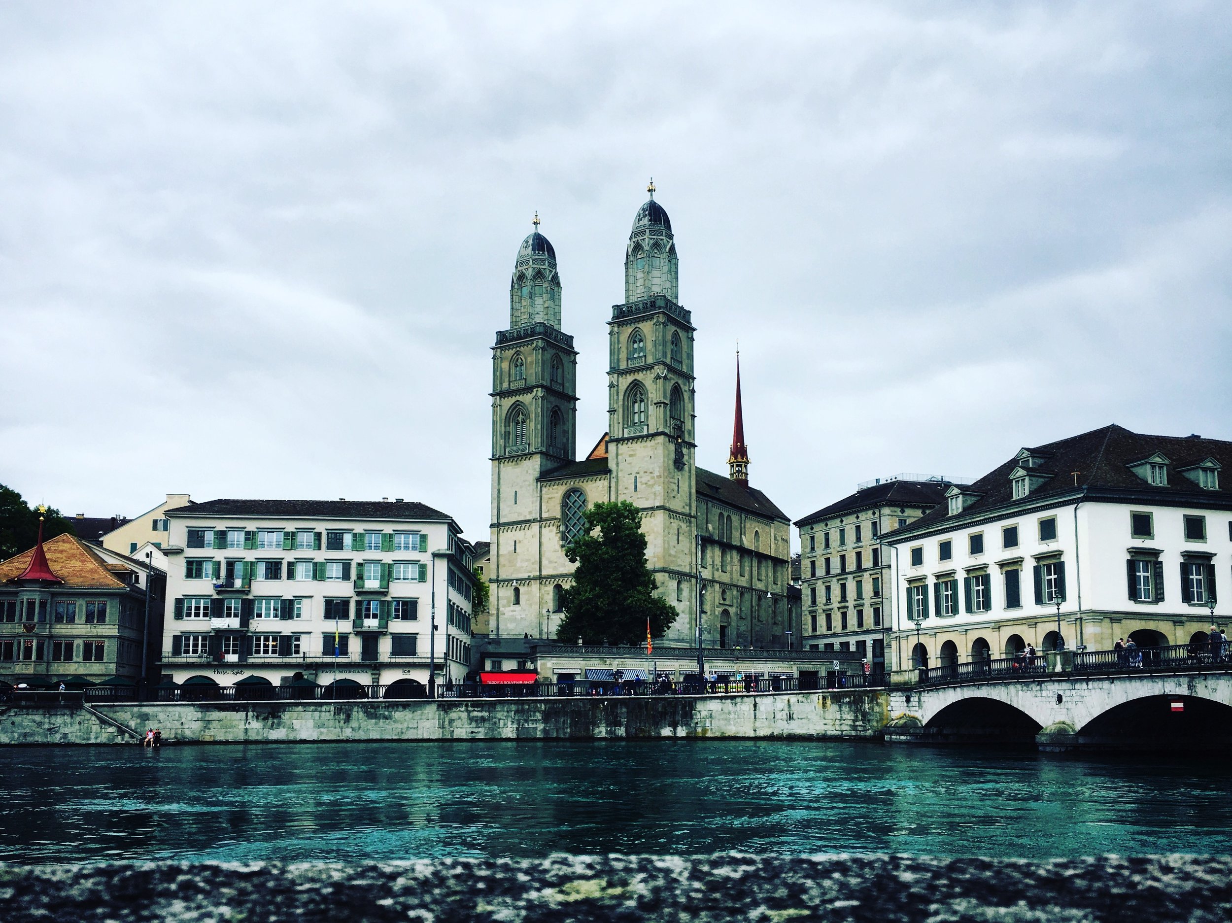Day 10: Grossmünster Northward rails to Zurich land upon the Limmat river, home to Grossmünster, a church said to be commissioned by Charlemagne. I was immediately thrown by the symmetry of the towers; it's not normal for religious sites to stand so even. Typically, churches have asymmetry in their architecture, particularly in their towers. You can see this most notably in the Church of Our Lady before Týn in Prague (with towers named: Adam and Eve), and even in secular architecture like the Smithsonian Castle in Washington, D.C. The story deepens, as I found that the original north tower (photo left) was higher than its twin, made to hold the church bells and conforming to the natural style of Old Europe. By the fifteenth century the south tower was built up to match, then both originals irreversibly ruined after a fire in the late seventeen hundreds. Still today, the south and north towers differ by a few pieces; adorations, and an extra decorative lintel on the fourth block of the south tower (photo right). I once wrote a whole book on asymmetry (re: Left) with a large section devoted to this topic. Sometimes the asymmetry serves a purpose, but more often than not, it is meant to represent dichotomies (e.g. right/left, good/evil), or in the case of some eastern artifacts, the asymmetry is introduced as an error in design to represent our failing as human beings, respecting the sanctity and faultlessness of the divine.