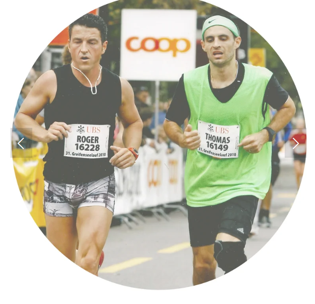 Two male runners competing in a marathon, one in black sports attire with a bib labeled Roger, and the other in a green vest with a bib labeled Thomas, running on a street with race banners and a 'Coop' sign in the background.