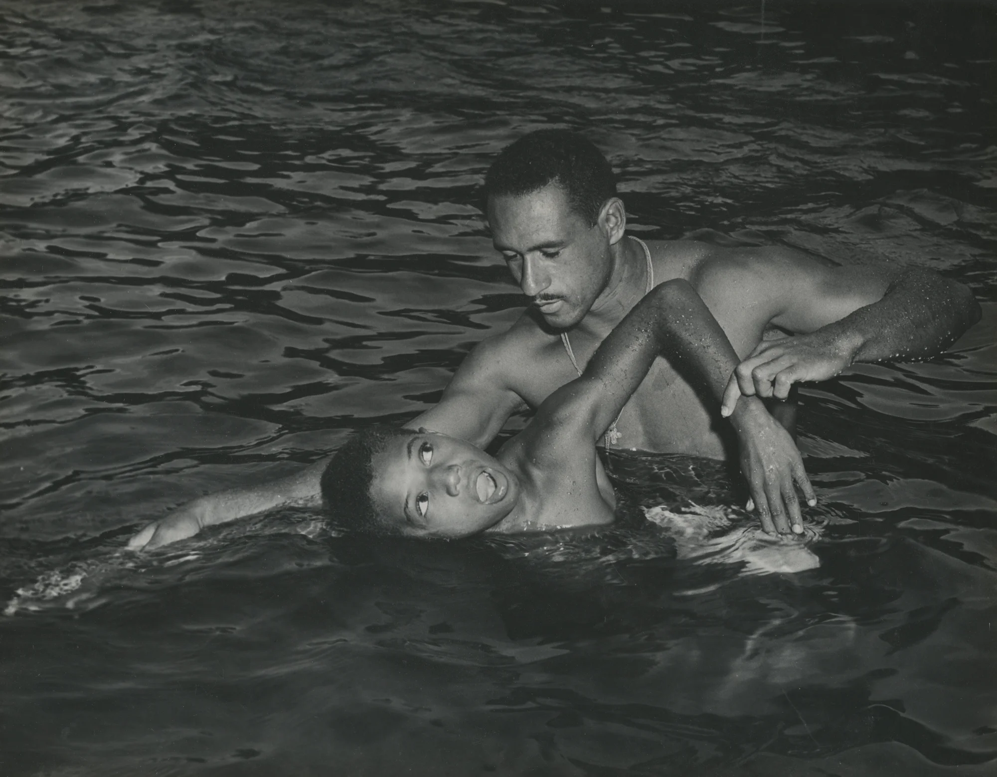 Clinton Coleman getting a swimming lesson from Life Guard Instructor Robert P. Meteye at Lafon Playground pool.