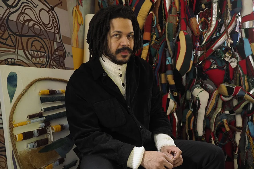 Leonardo in the studio. To the right, Beings Born From Word and Stitch.  Photo by Henry Adebonojo for THE TROVE.