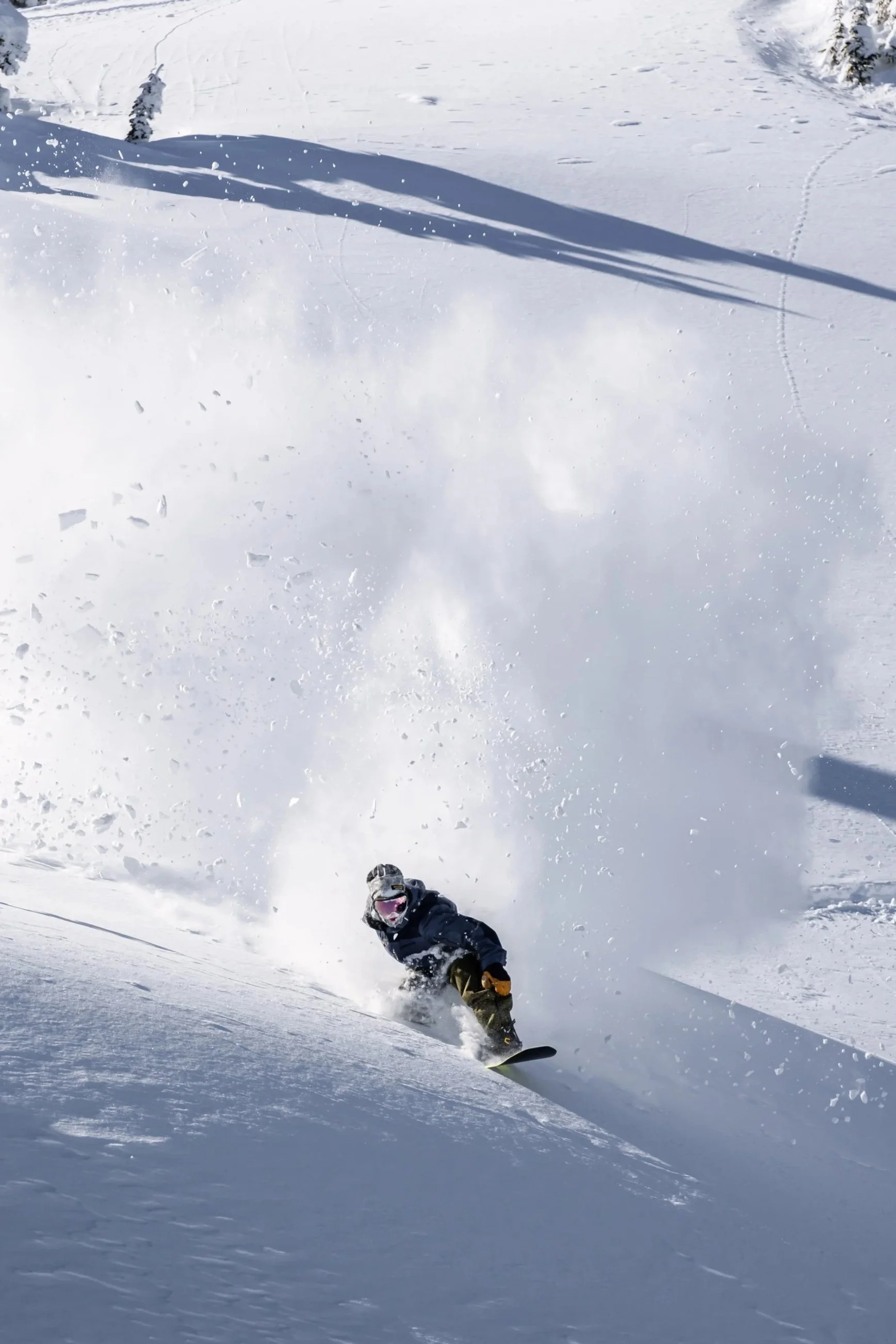 Person snowboarding down a snowy mountain slope.