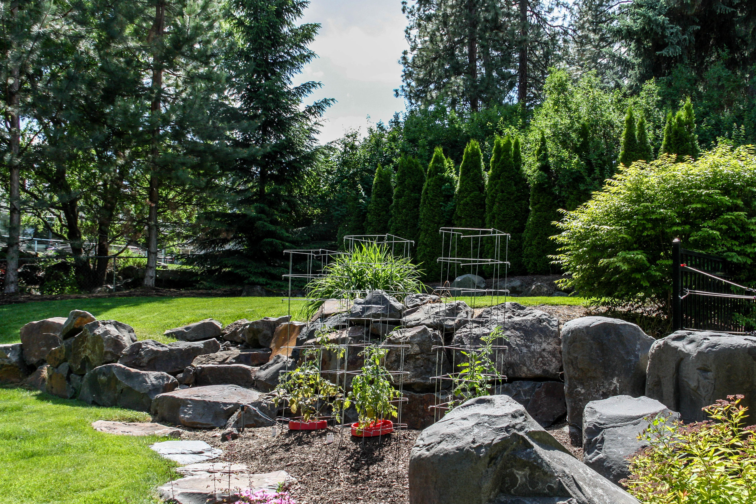 basalt boulder retaining wall with steps and vegetable garden