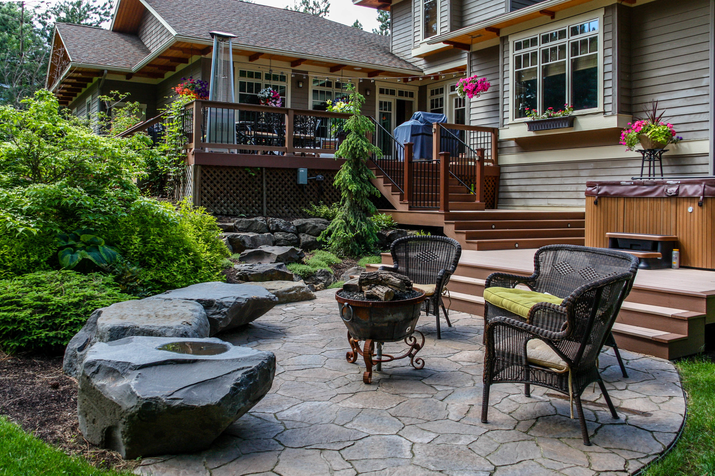 paver patio and bench rocks off of multi level deck