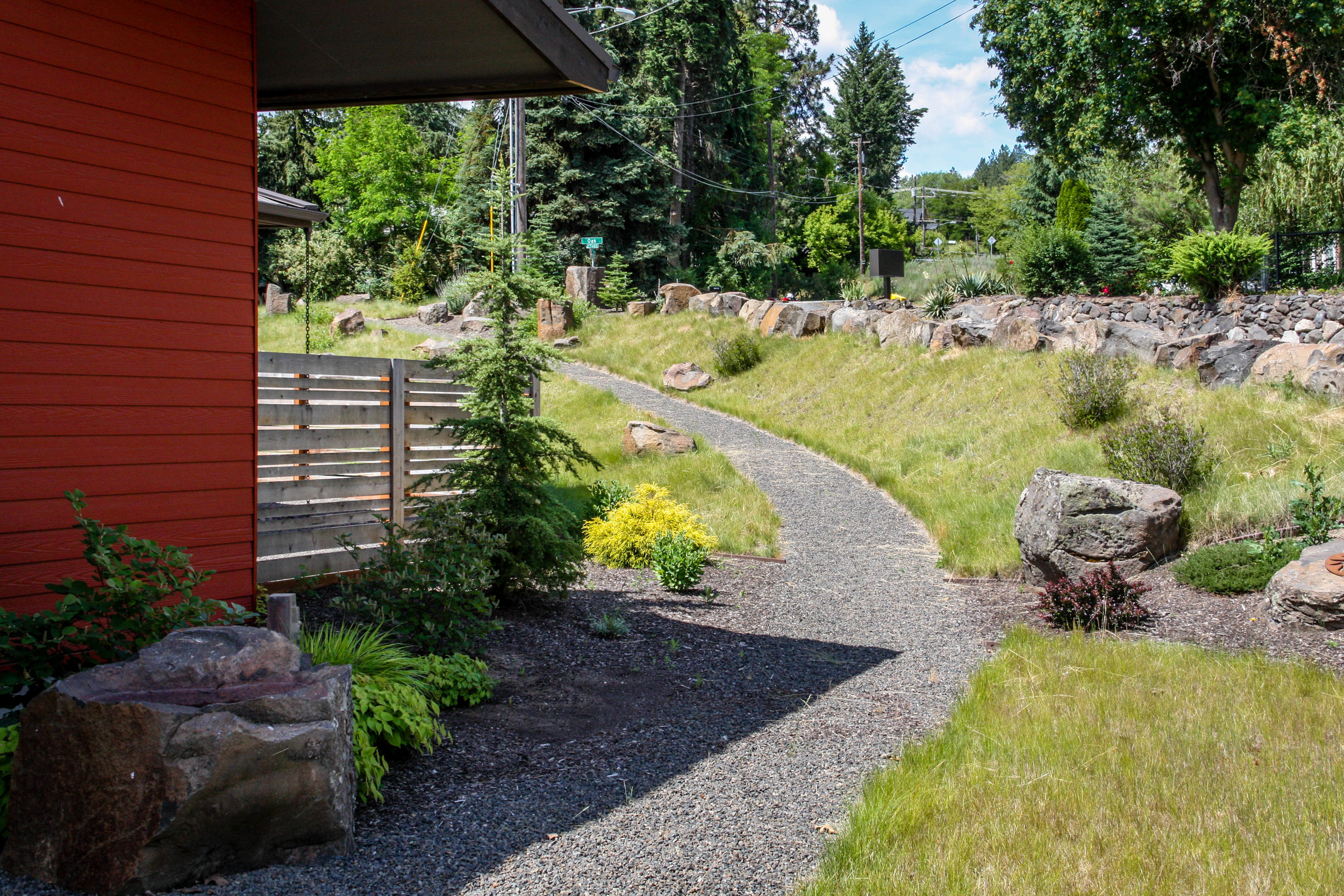 gravel pathway on hillside and horizontal wood fence