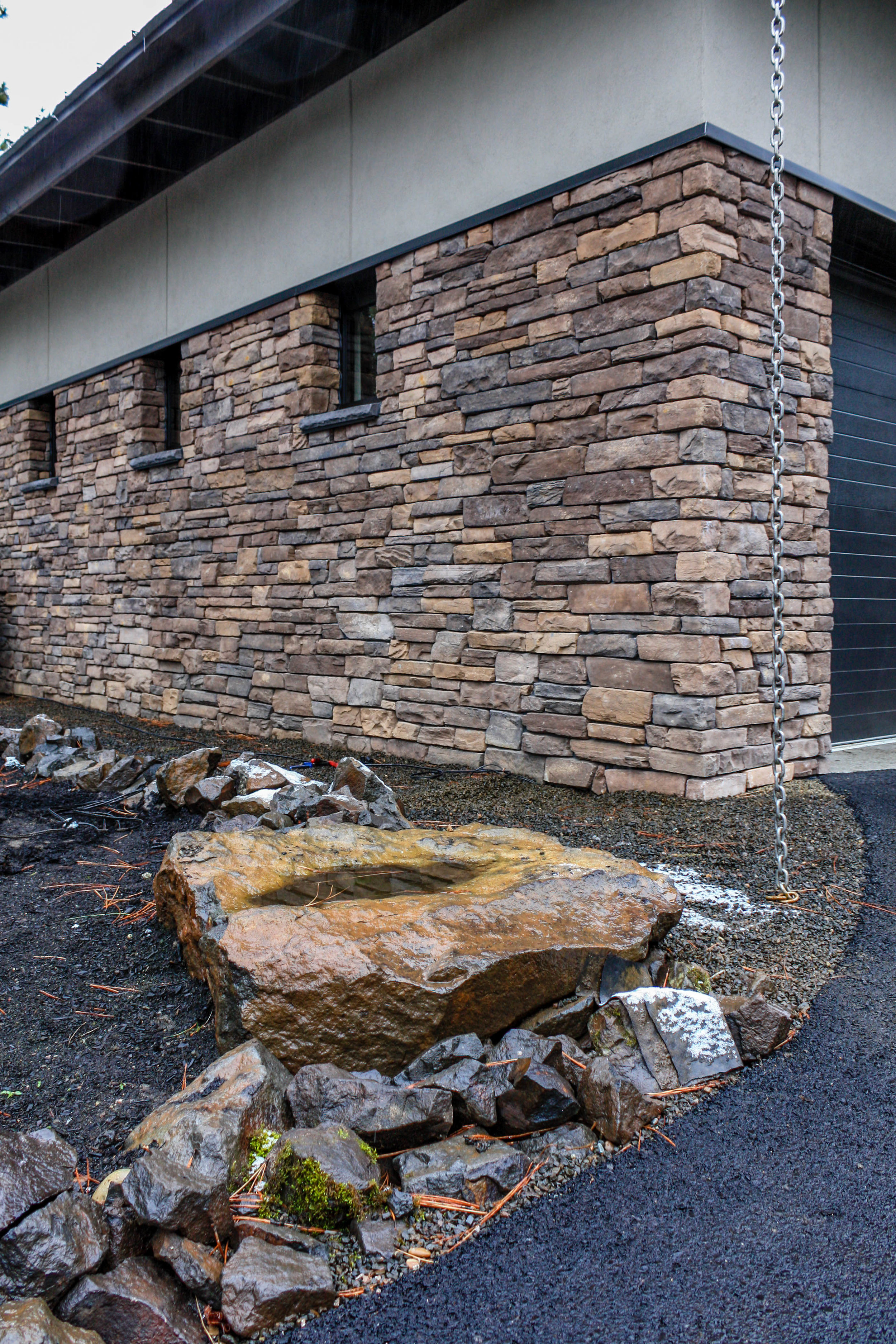 northwest contemporary landscaping with rain chain and rock work